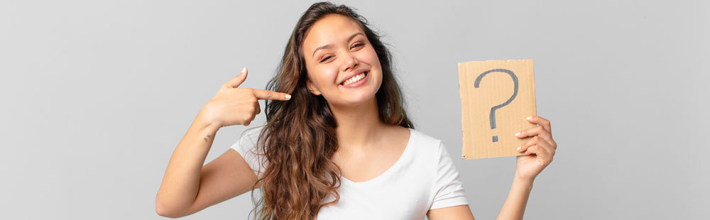 faq-woman-smiling-points-with-her-finger-at-a-question-mark-in-the-other-hand-WerbeCenter-Berlin